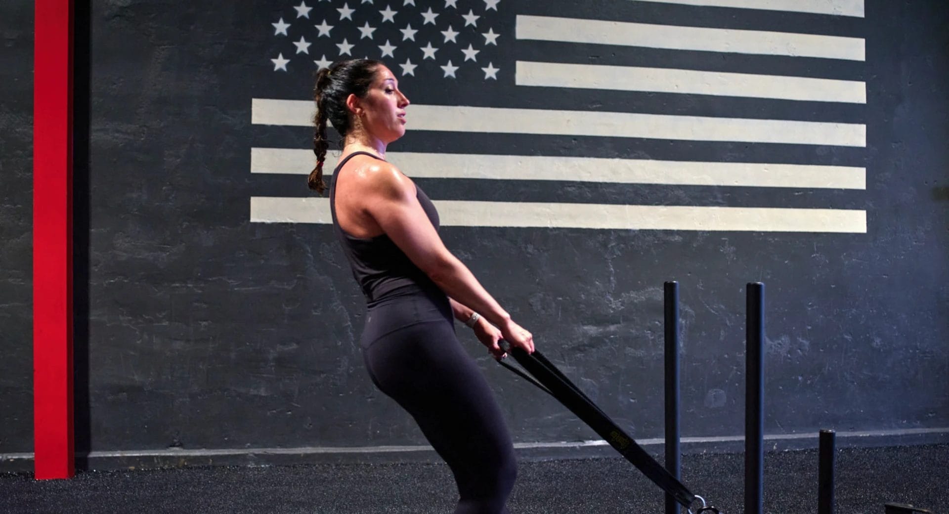 Woman pulling weighted sled in gym